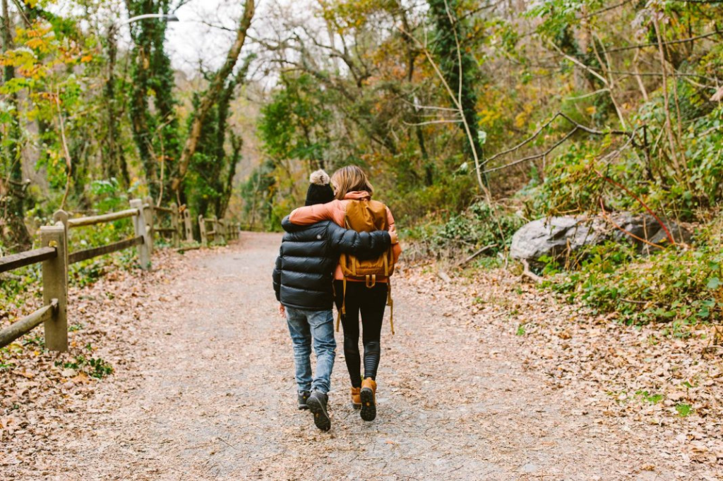 Mom and daughter hiking a scenic mountain trail together. Explore nature's beauty with Kalouded gear.